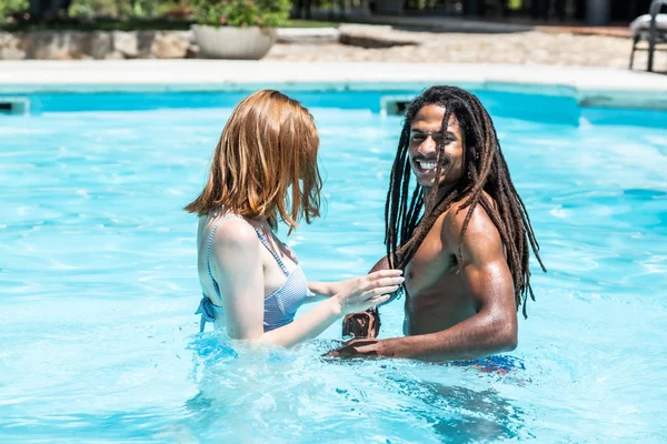 非裔美国男人和白人女人在游泳池里玩耍. — 图库照片