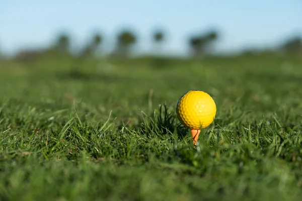 Yellow golf ball on the ground at the driving range — 스톡 사진