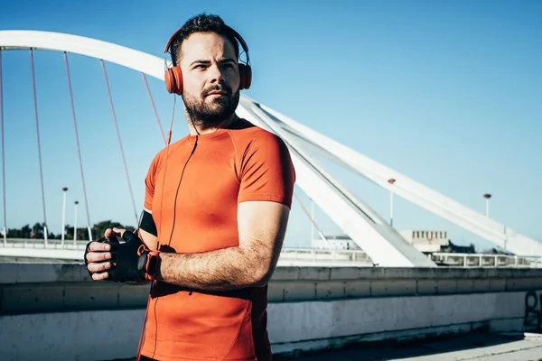 Adam spor yapıyor ve kulaklıkla müzik dinliyor.