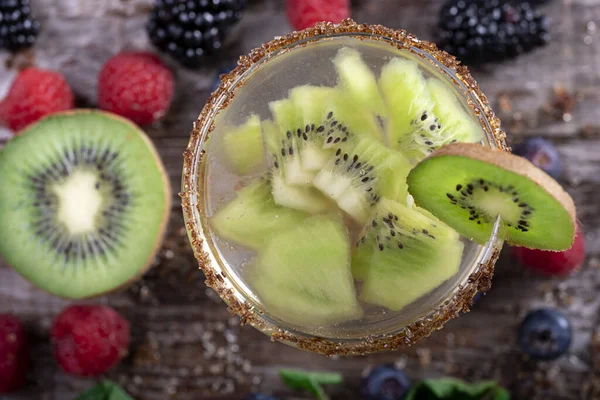 Kiwi cocktail van bovenaf gedecoreerd met vruchten van het bos op een houten achtergrond — Stockfoto