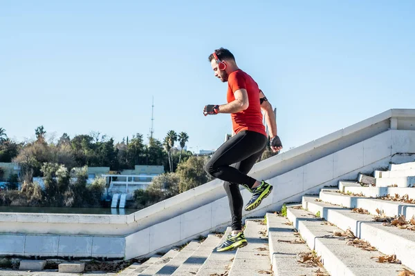 Man running down a flight of stairs and listening to music — Stock Photo, Image