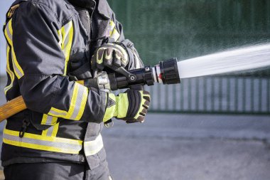 Yangın söndürücü ve hortum suyu kullanan itfaiyeciler yangınlarla savaşmak için.