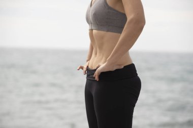 Denizde hipopresif egzersiz yapan bir kadın.