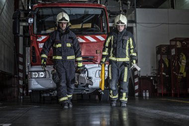 İtfaiyeciler, yangını söndürmek için gerekli ekipmanlarla istasyondan ayrılıyorlar.