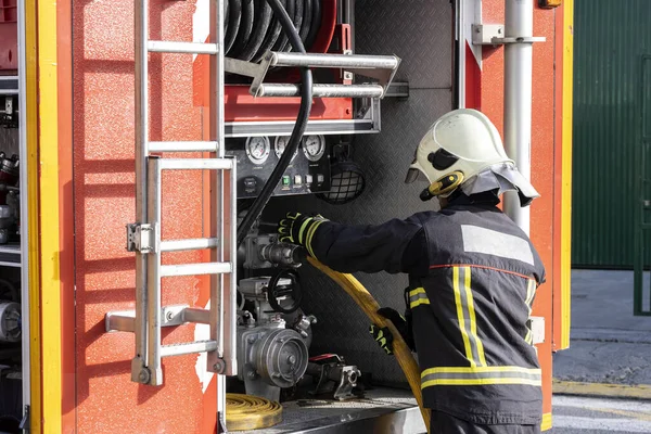 Ausgestatteter Feuerwehrmann Der Mit Einer Wasserabsaugpumpe Hantiert Einem Löschfahrzeug — Stockfoto