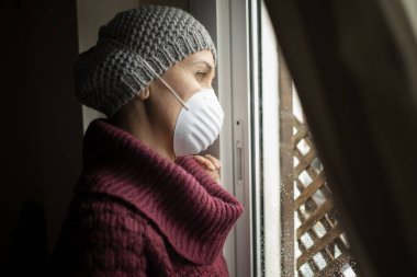 Evde maskeli bir kadın, Corona virüsü ve karantina konsepti.