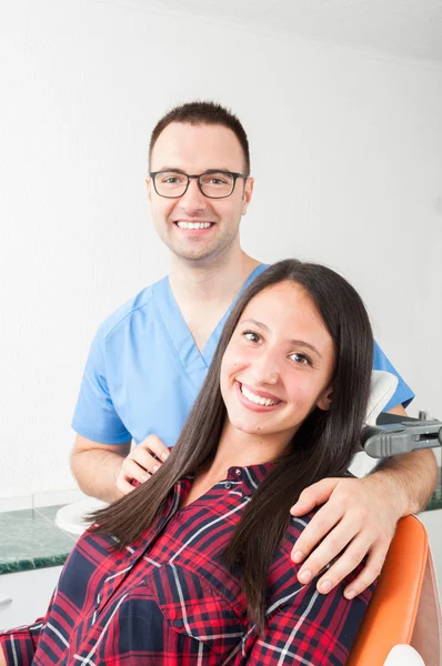 Senhora sentada na cadeira do dentista com o médico de lado — Fotografia de Stock