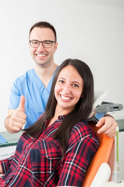 Dentista con paciente en silla mostrando el pulgar hacia arriba — Foto de Stock
