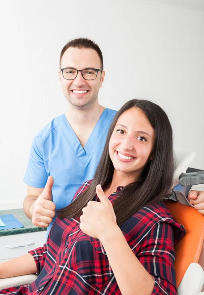 Lady och tandläkare i skåp visar tummen upp — Stockfoto