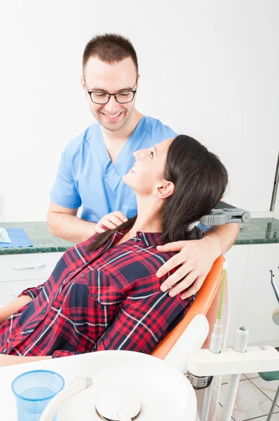 Dentiste souriant tenant son patient comme étant amical — Photo