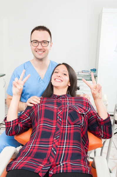 Señora paciente e higienista siendo feliz mostrando paz — Foto de Stock