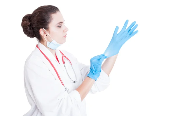 Νεαρή γυναίκα γιατρό βάζοντας γάντια σε — Φωτογραφία Αρχείου