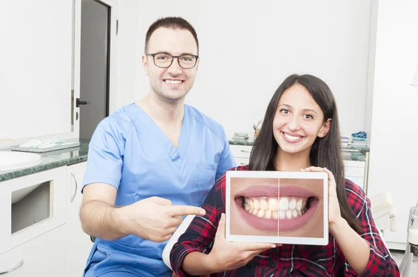 Orthodontist and patient pointing on tablet and smiling — Stock Photo, Image