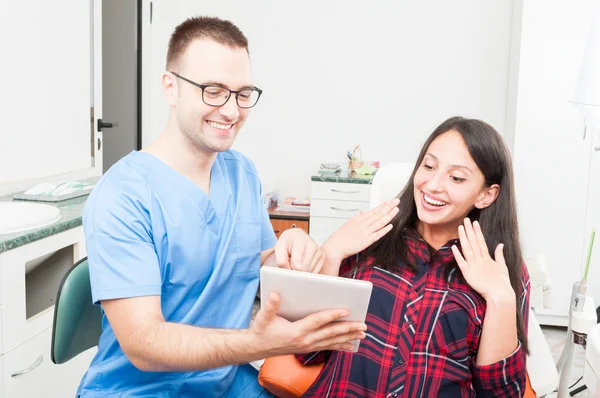 Dentist with patient showing something on tablet — Stock Photo, Image