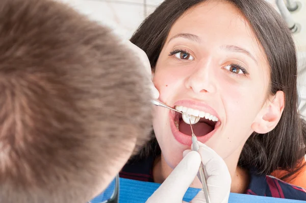 Jovencita paciente siendo inspeccionada por dentista — Foto de Stock