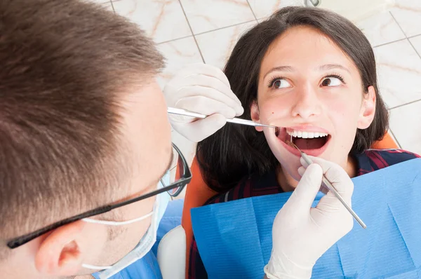 Mädchen sitzt auf Zahnarztstuhl und lässt sich beraten — Stockfoto