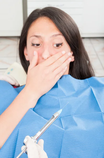 Dama en silla de dentista asustada por la aguja anestésica — Foto de Stock