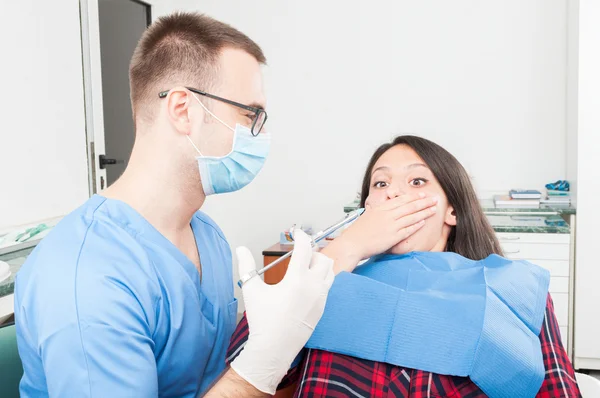 Hygieniker mit verängstigter Patientin zeigt Spritzennadel — Stockfoto