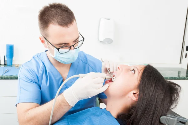 Mädchen sitzt im Zahnarztstuhl und lässt sich vom Arzt beraten — Stockfoto