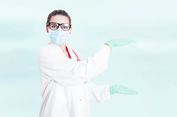 Unga medic mäta något med handflatorna — Stockfoto
