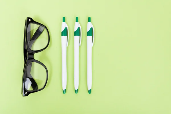 Groene werkruimte met potloden en brillen — Stockfoto