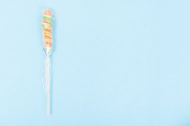 Mavi arka plan üzerinde renkli bükülmüş lolipop