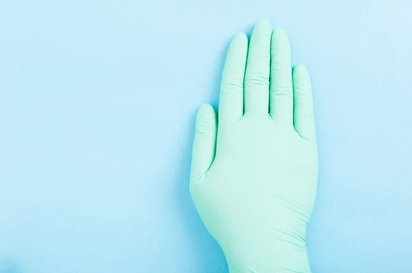 Tıbbi lastik eldiven mavi zemin üzerine — Stok fotoğraf