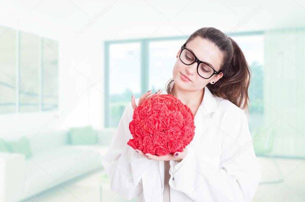 Pretty female medic holding red bouquet