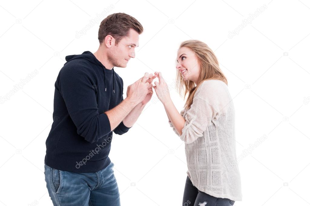 Attractive couple showing fingers crossed to each other