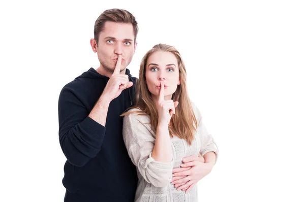 Linda pareja haciendo gesto de silencio con el dedo índice —  Fotos de Stock