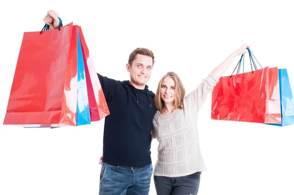 Casal feliz segurando um monte de sacos de compras — Fotografia de Stock