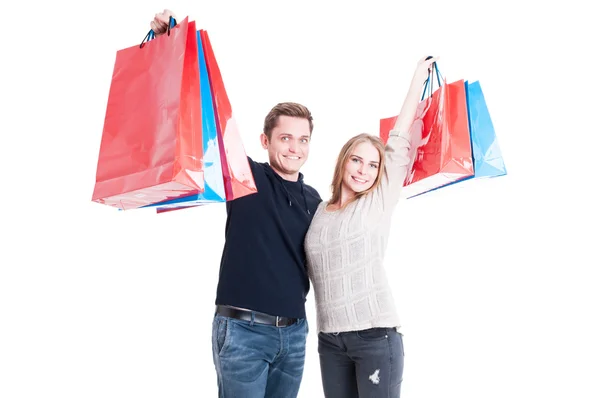 Casal feliz segurando um monte de sacos de compras — Fotografia de Stock