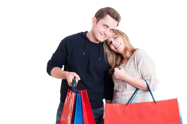 Bonito casal feliz segurando um monte de sacos de compras — Fotografia de Stock