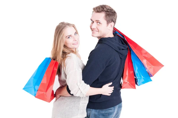 Casal atraente abraçando segurando um monte de sacos de compras — Fotografia de Stock