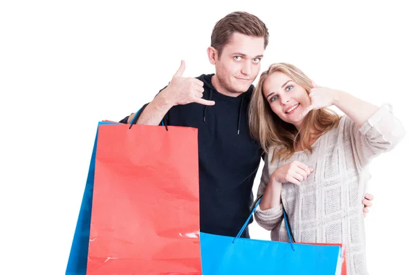 Paar mit Einkaufstüten macht telefonierende Geste — Stockfoto