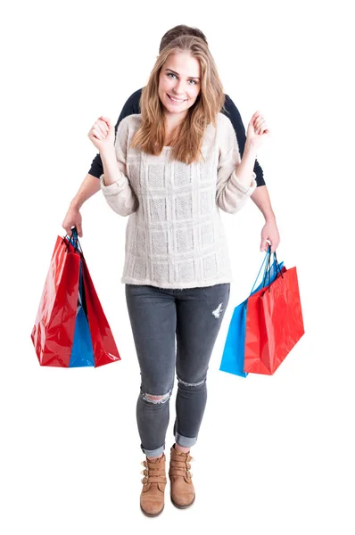 Man holding shopping bags hiding behind woman — Stock Photo, Image