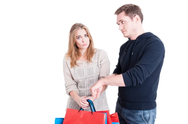 Man making being late gesture to woman holding shopping bags Royalty Free Stock Images