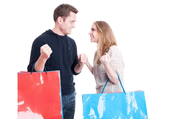 Casal segurando sacos de compras fazendo gesto vencedor — Fotografia de Stock