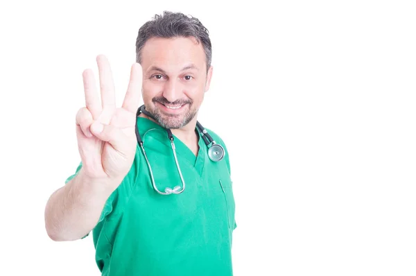 Mladý zdravotník zobrazující číslo tři s jednou rukou — Stock fotografie