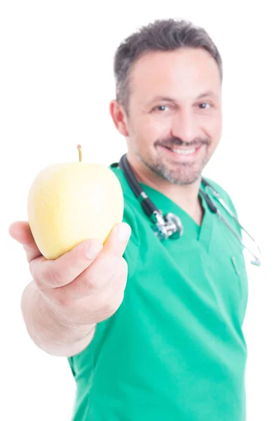 Wesoły, młody lekarz, wyciągając świeżego jabłka — Zdjęcie stockowe