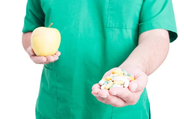 Doctor offers patient capsules and apple — Stock Photo, Image