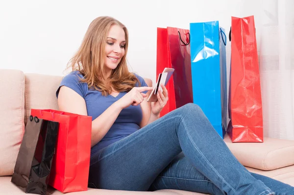 Woman sitting on couch making an online order — Stock Photo, Image