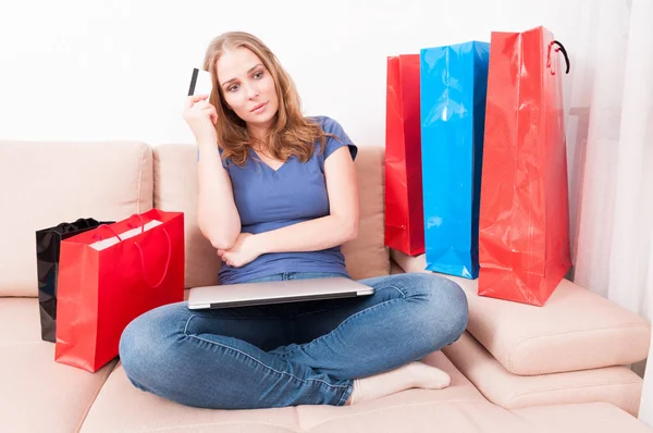 Woman sitting on couch feeling pensive of something — Stock Photo, Image