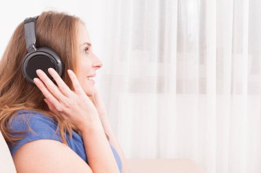 Yan görünümü Bayan Divan kulaklık dinleme keyfi