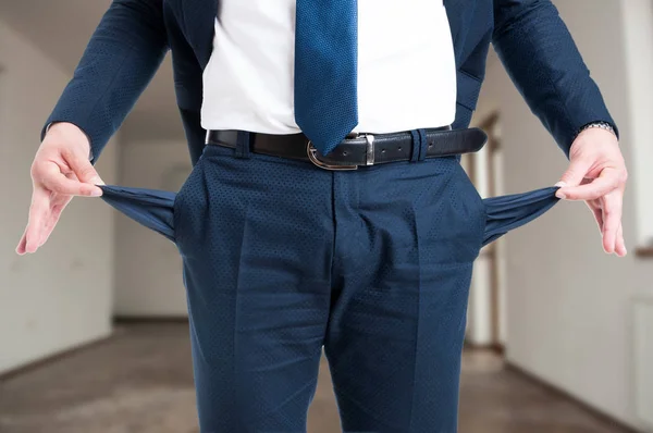 Primer plano del agente inmobiliario masculino mostrando sus bolsillos vacíos —  Fotos de Stock