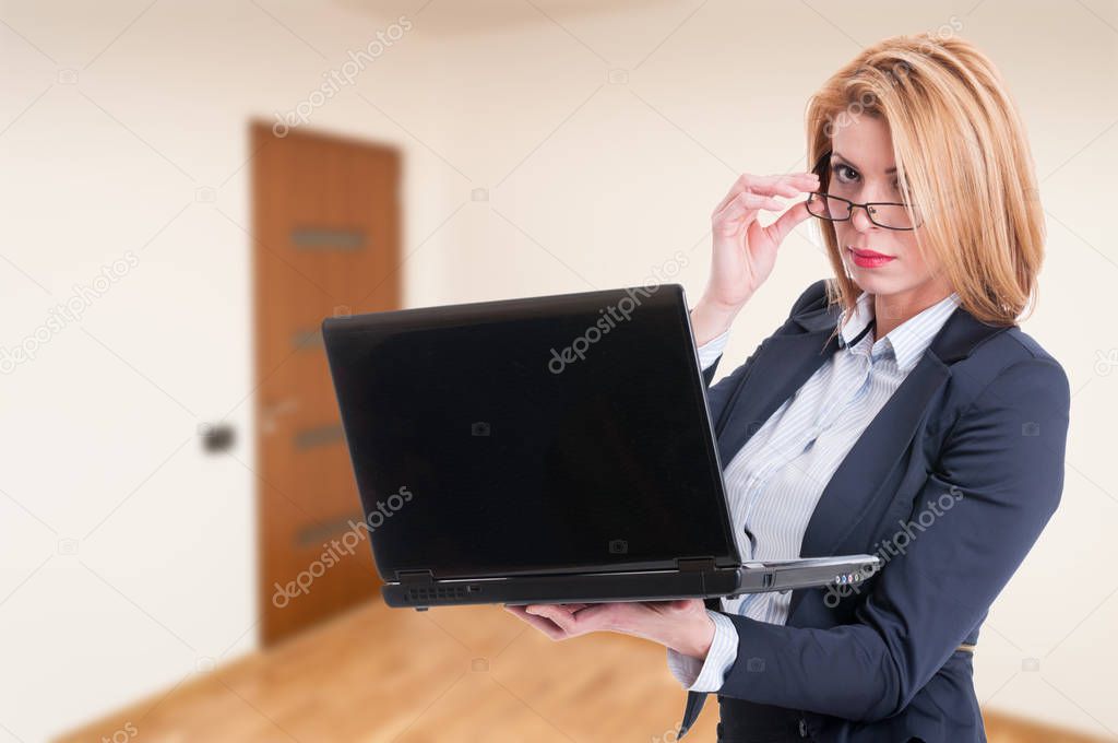 Attractive female agent browsing on laptop