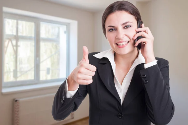 Portrait of happy female broker showing thumb up