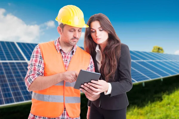 Young architect and elegant female browsing on tablet — Stock Photo, Image