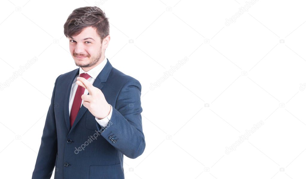 Handsome man wearing suit making fingers crossed gesture