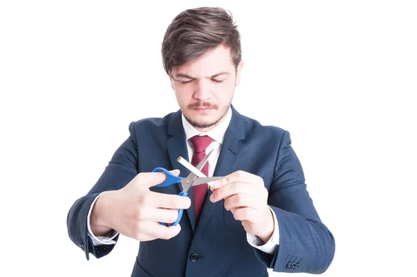 Man wearing suit cutting cigarettes with eyes closed — Stock Photo, Image